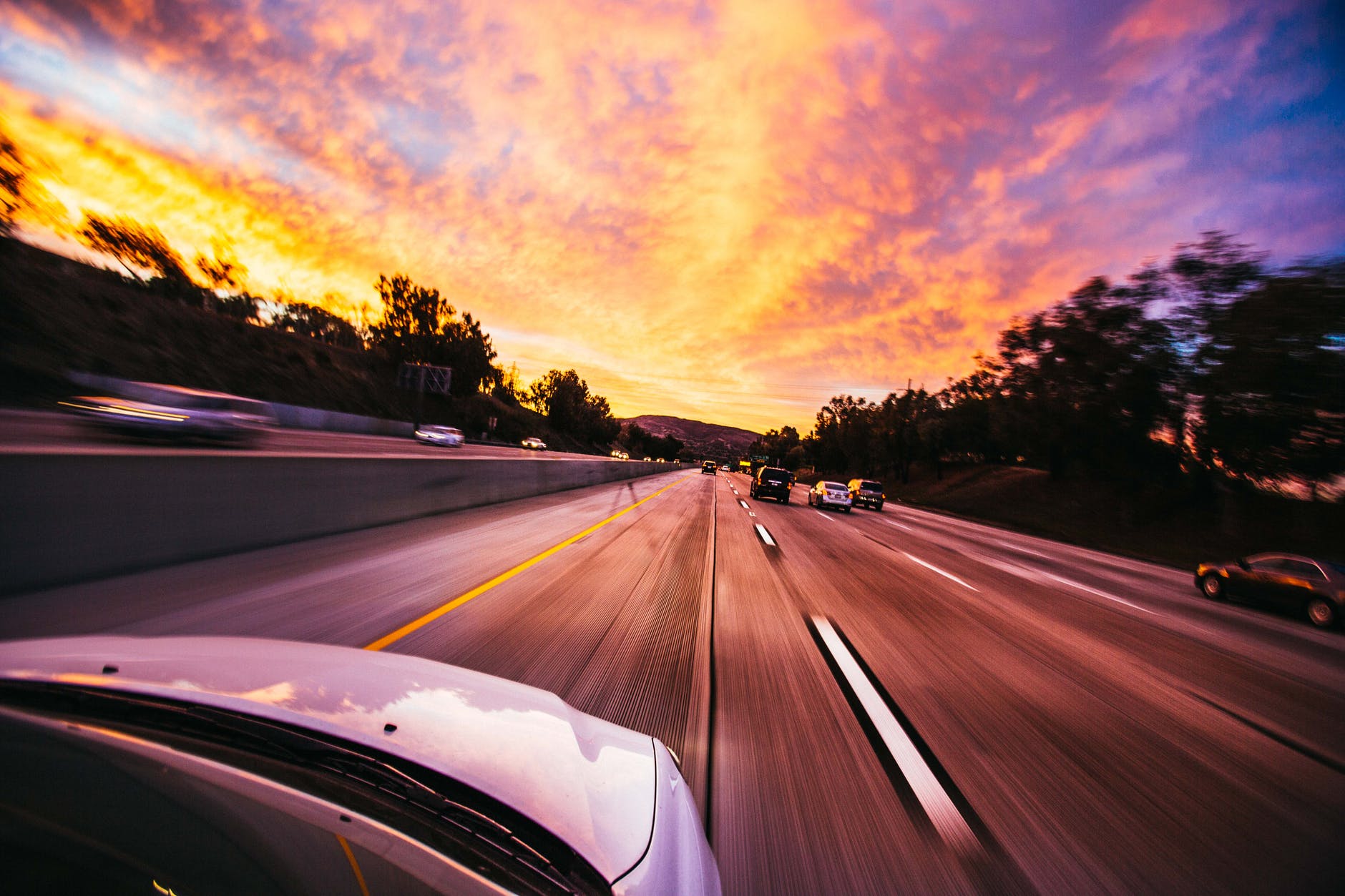 A car driving down a motorway at sunset