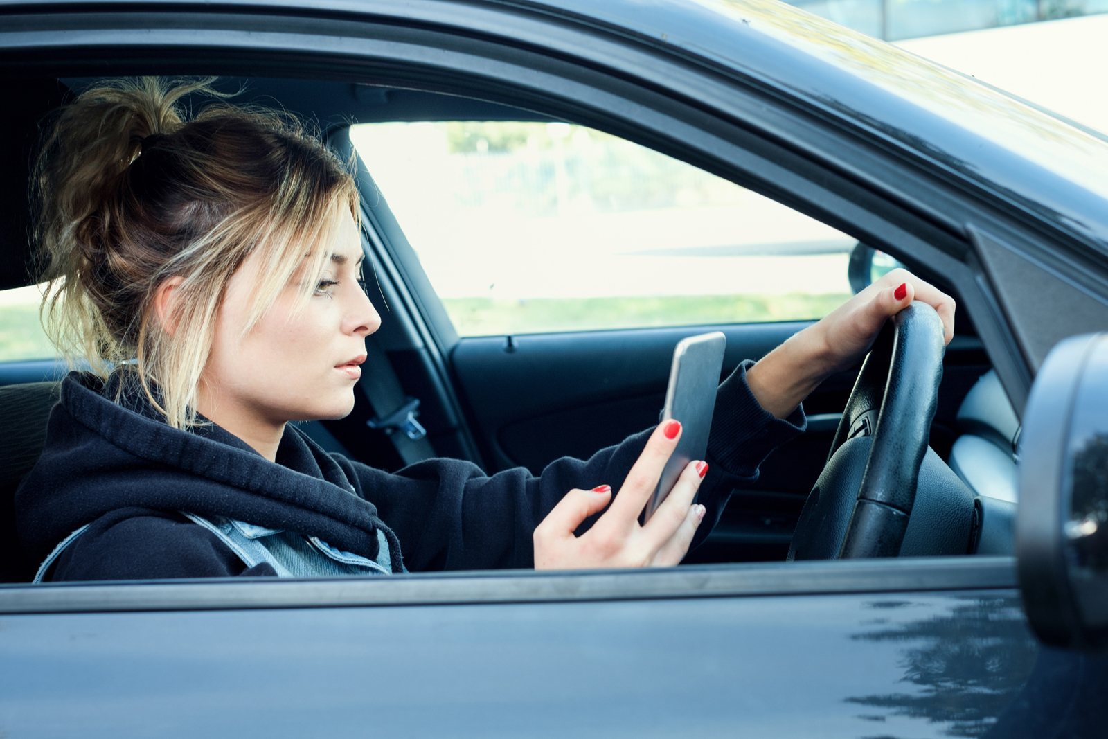 A woman driving and using her phone at the same time