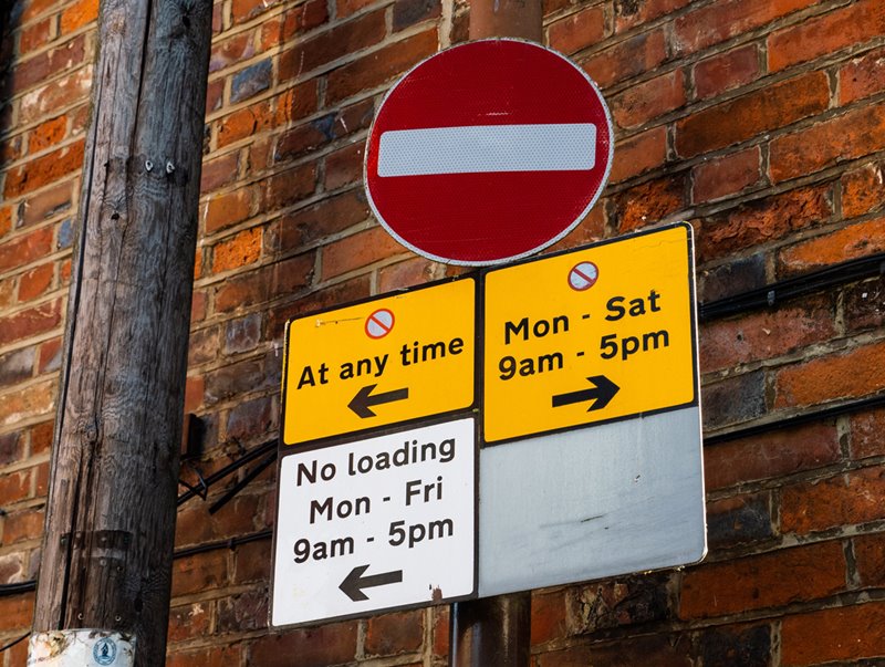 Multiple road signs indicating no parking is allowed