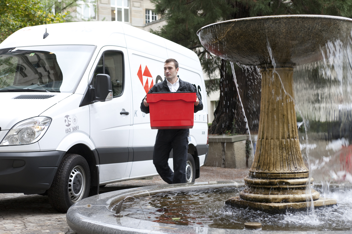 A courier driver walking a package to a house on a delivery