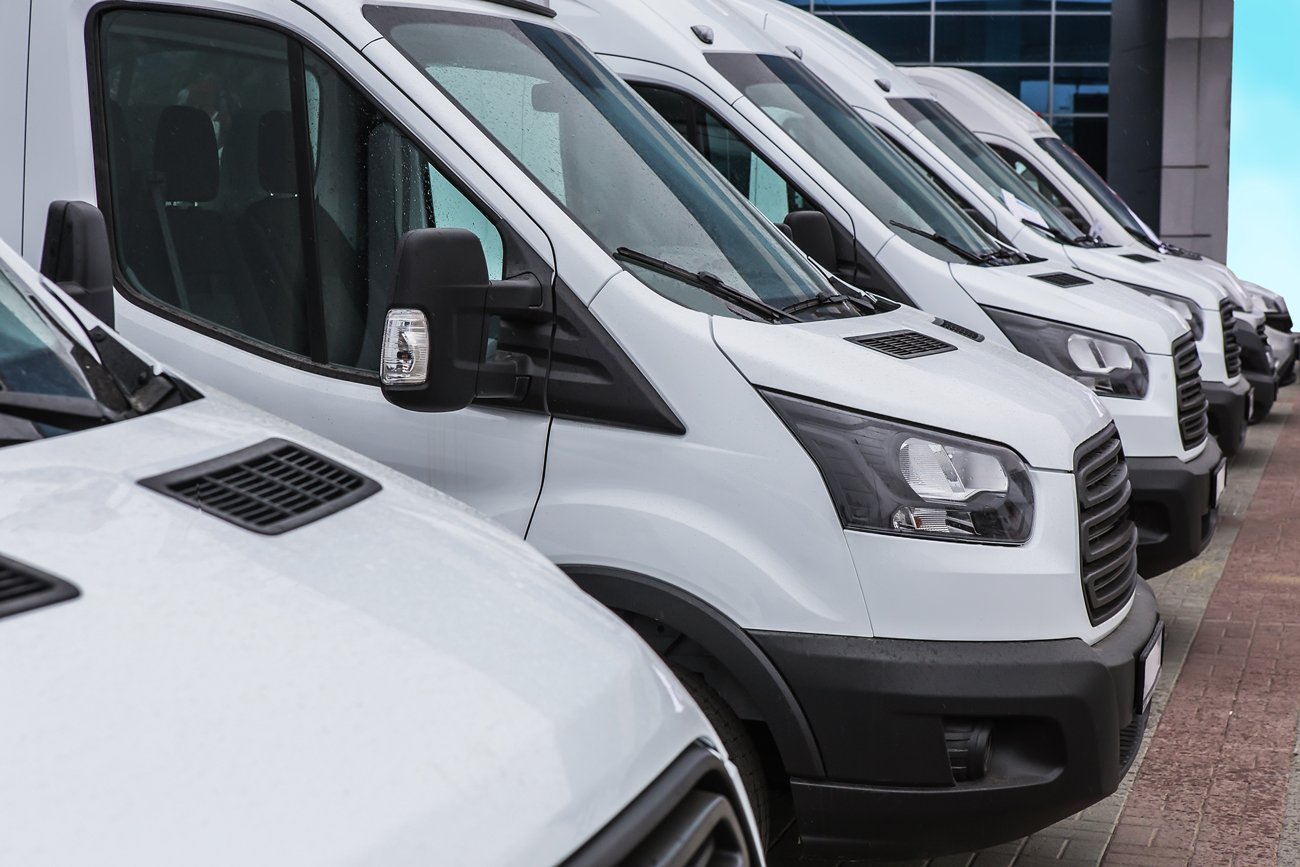A line of vans parked on a forecourt for sale