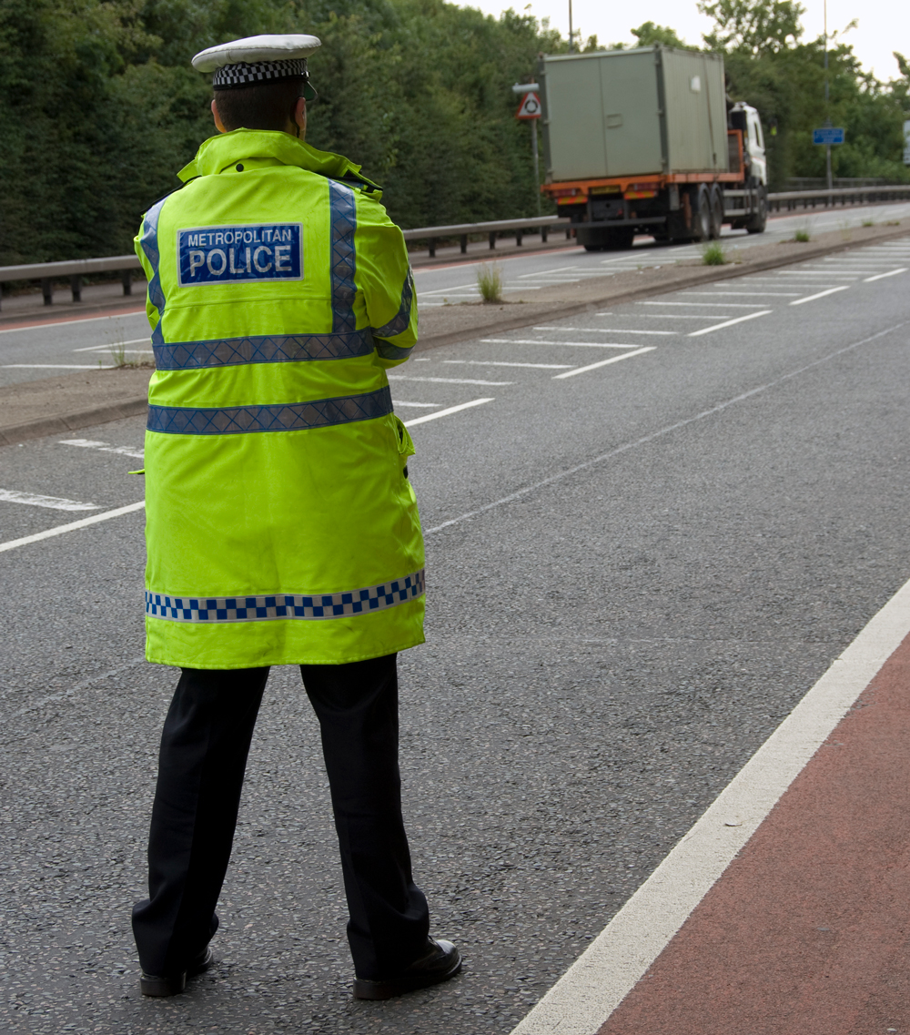A policeman watching a busy motorway