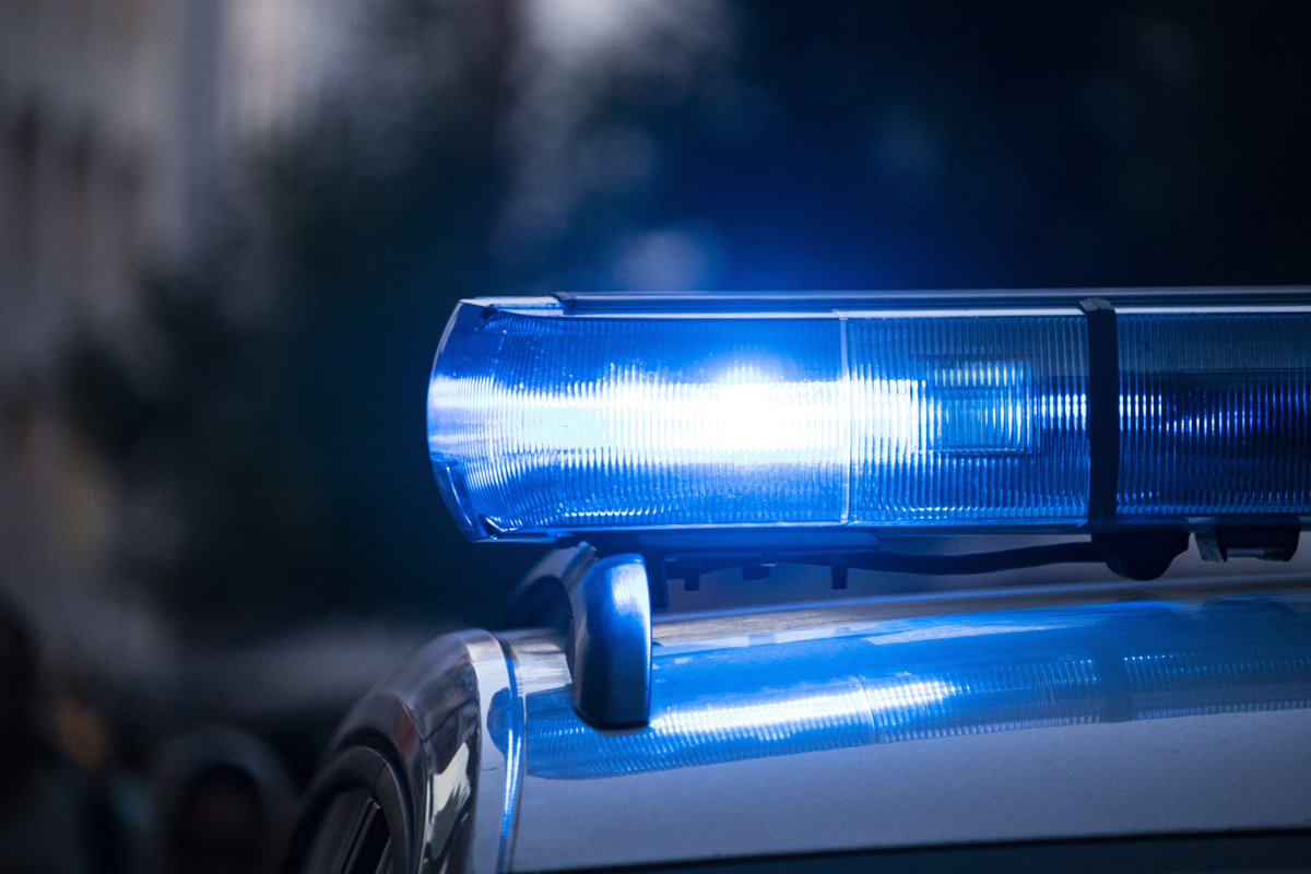 A blue police siren flashing on top of a police car