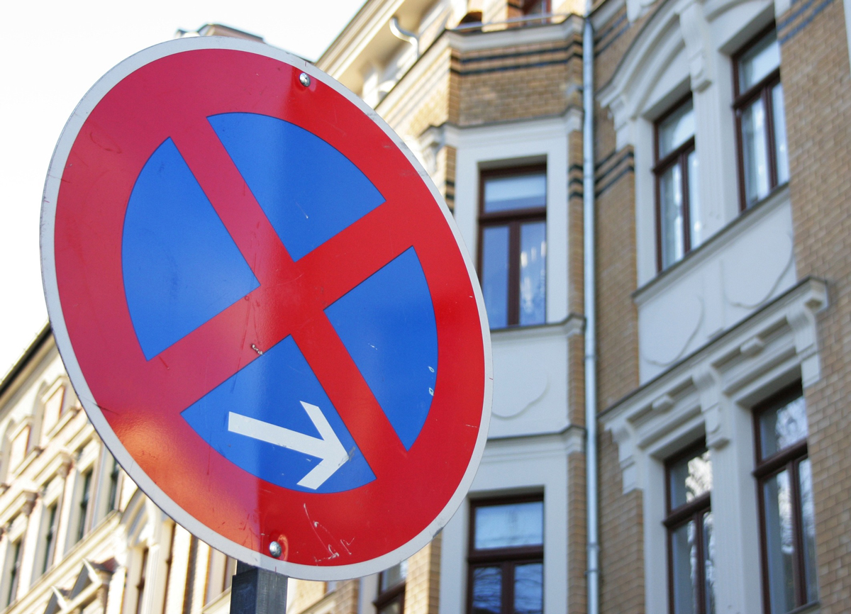 A road sign of a red x over a blue backgrond