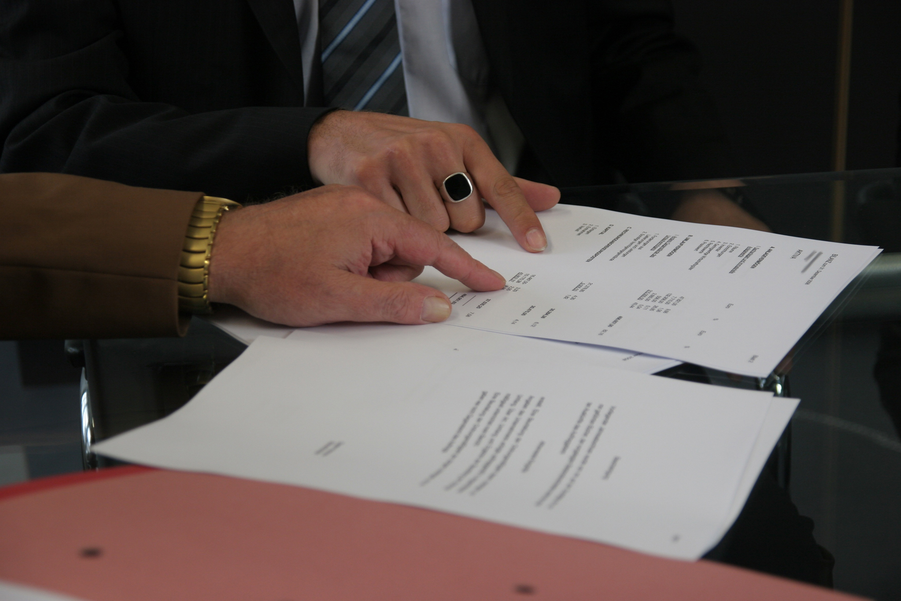 A man signing a document with a  broker pointing at it
