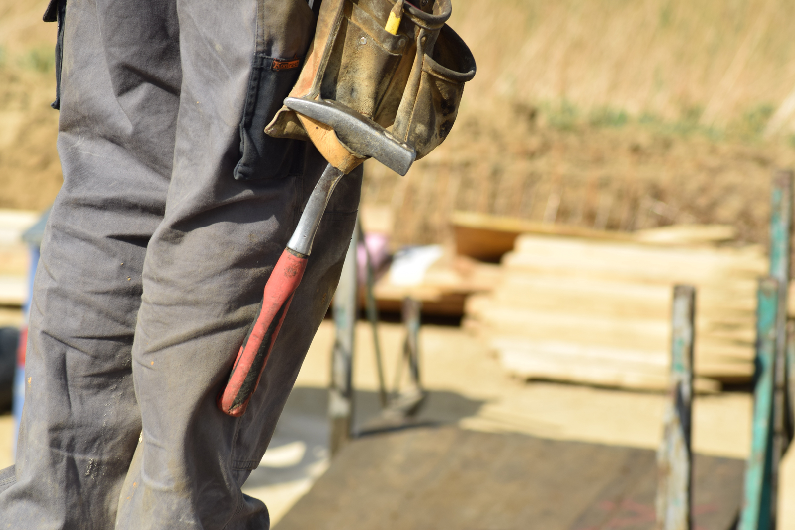 A construction worker with a hammer hanging from their belt