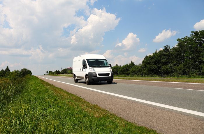 White van on a wide road in the country side