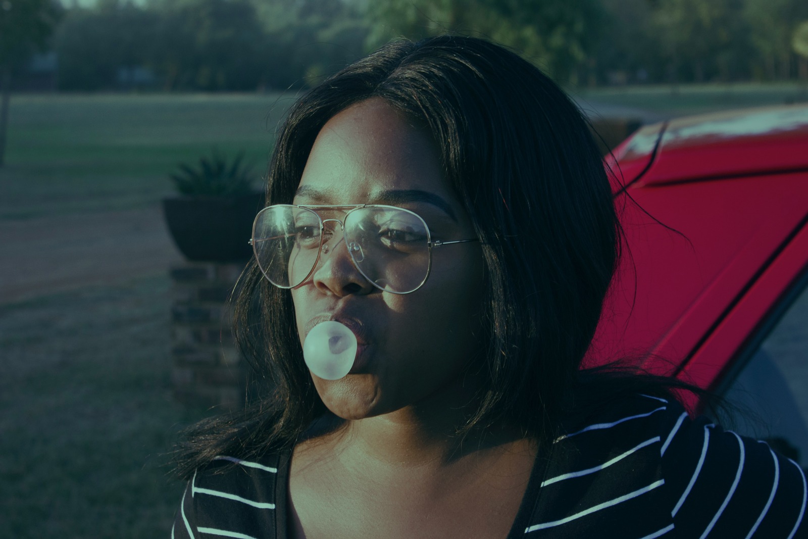 A person chewing gum next to a car