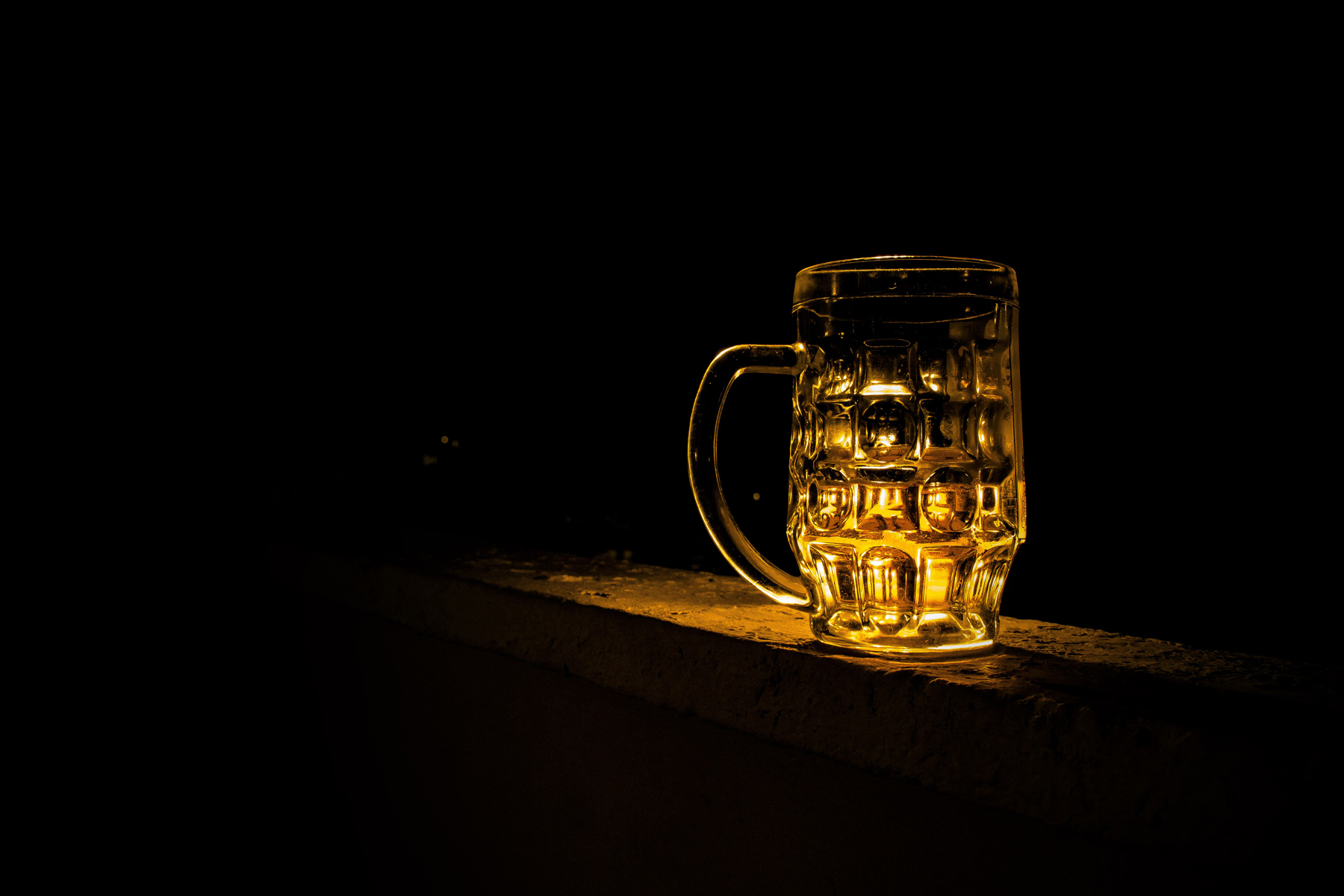 An empty beer glass in a dark room