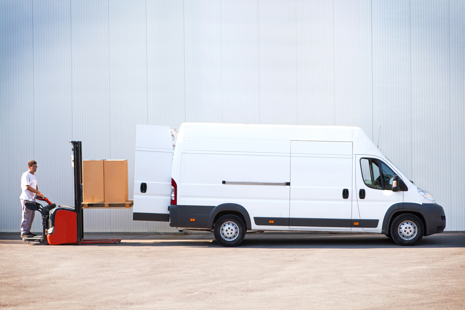 A delivery driver unloading boxes from his van