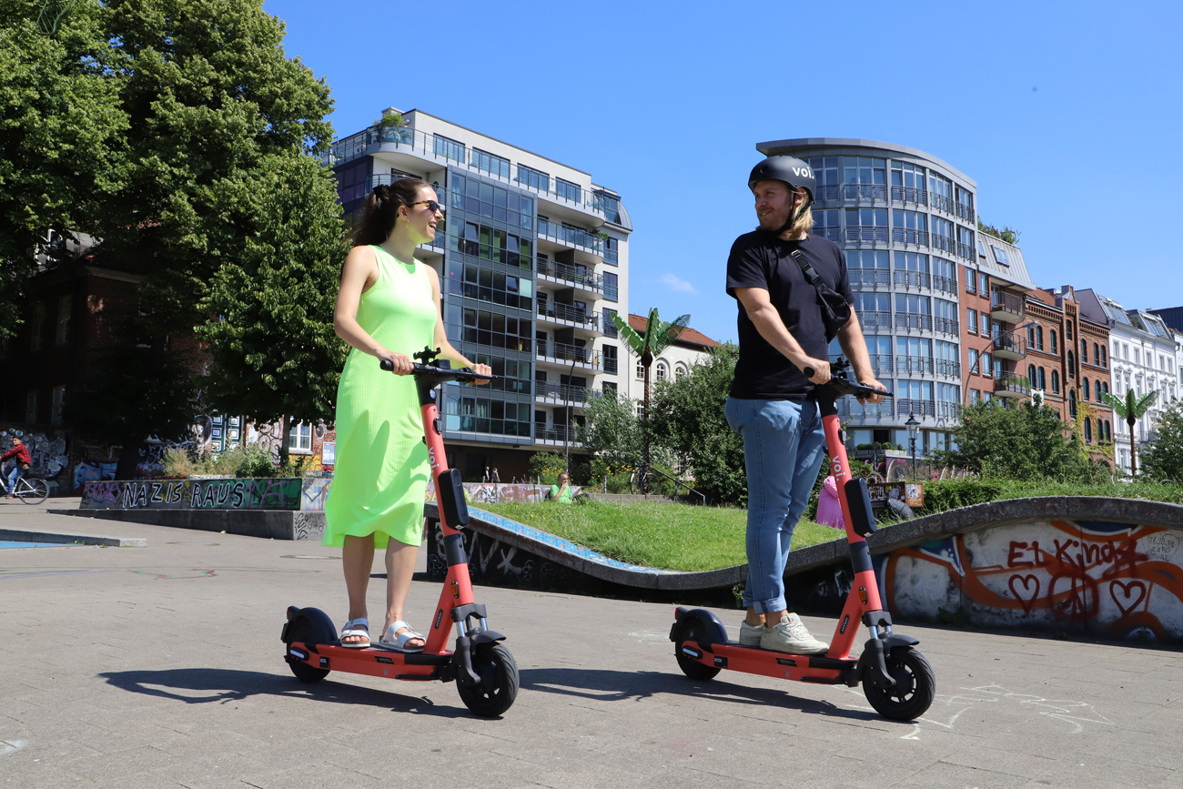 Two people riding e-scooters