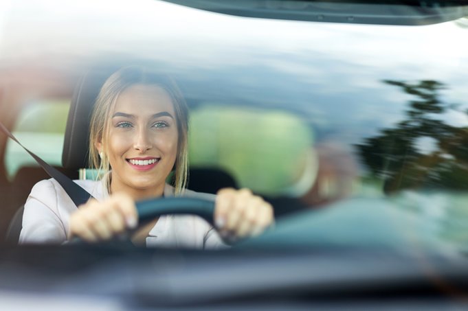 A young girl smiling as she drives