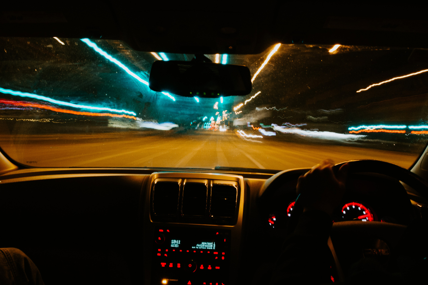 A view from the inside of a car as the road and lights in front are blurred indicating intoxication