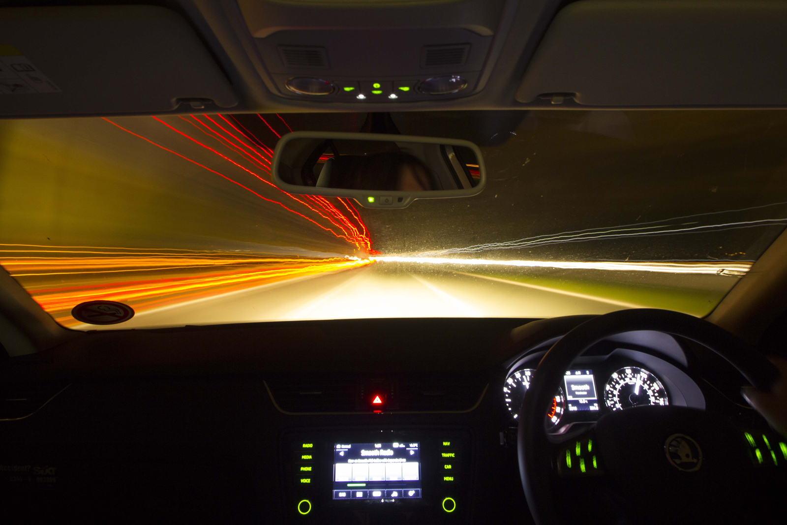 A person driving at high speed with the outside of the car a blur of lights